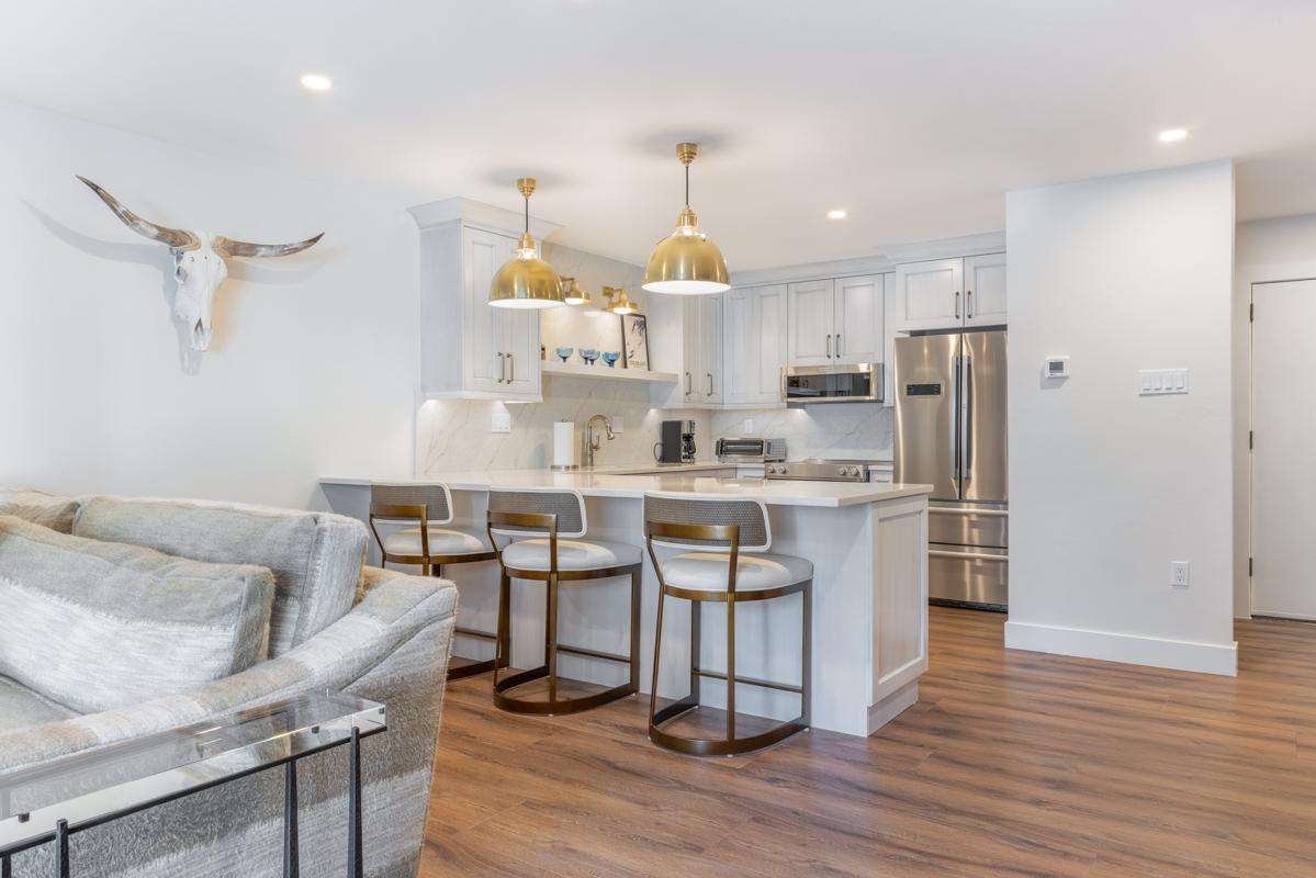 Bright, open kitchen with stylish island seating and modern appliances - property