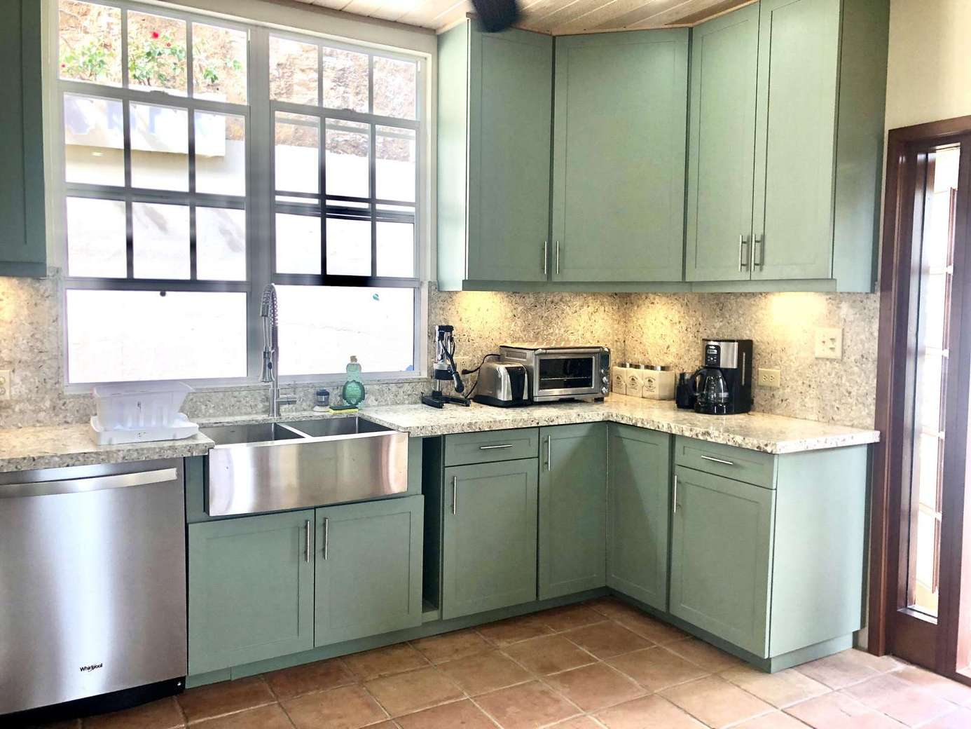 Bright kitchen with farmhouse sink and mint green cabinets