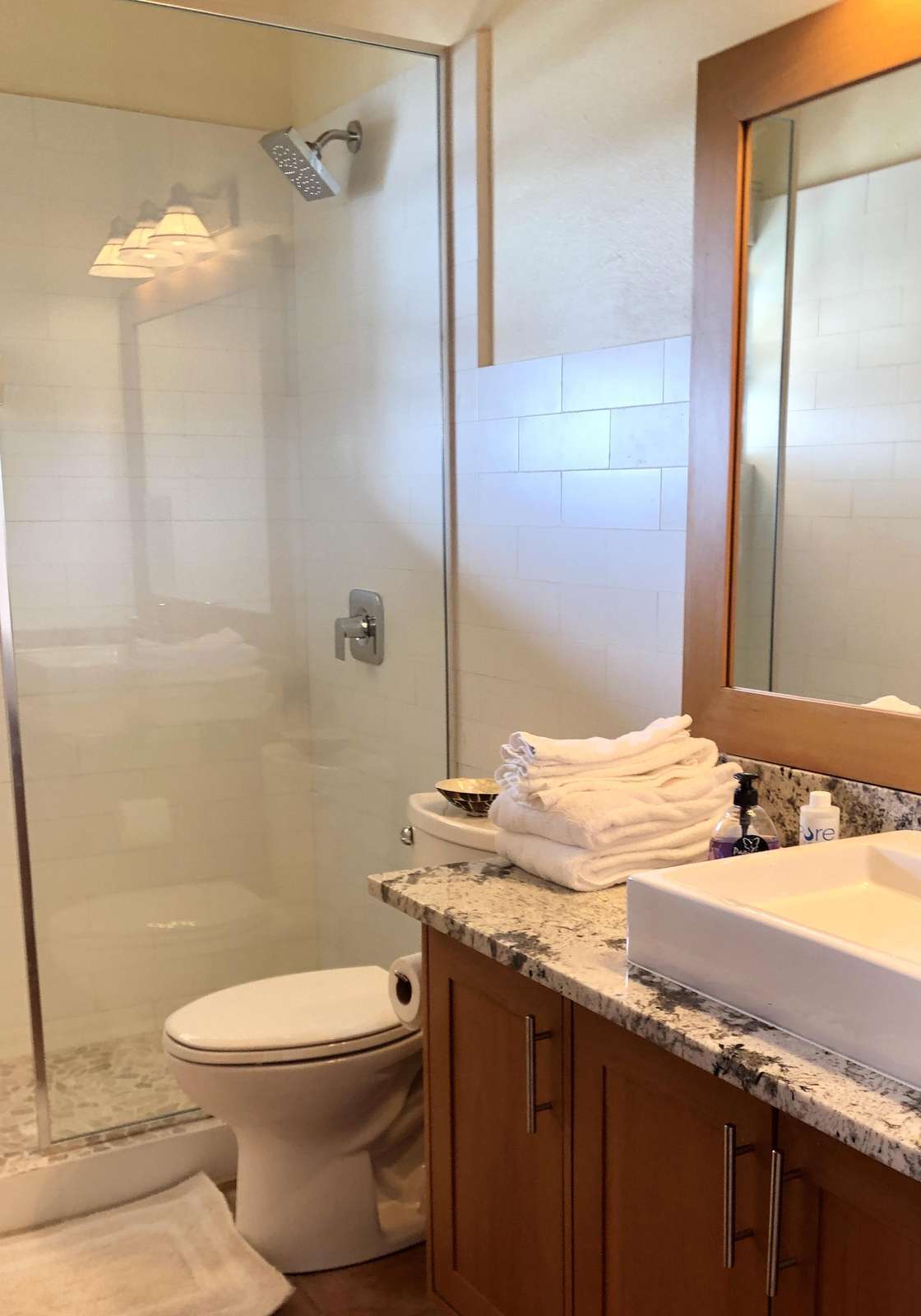 Bright, modern bathroom with spacious glass shower and elegant vanity