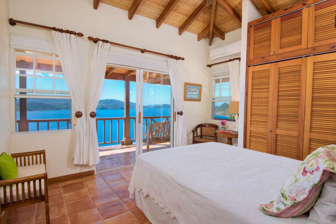 Cozy bedroom with vaulted ceilings and ocean views