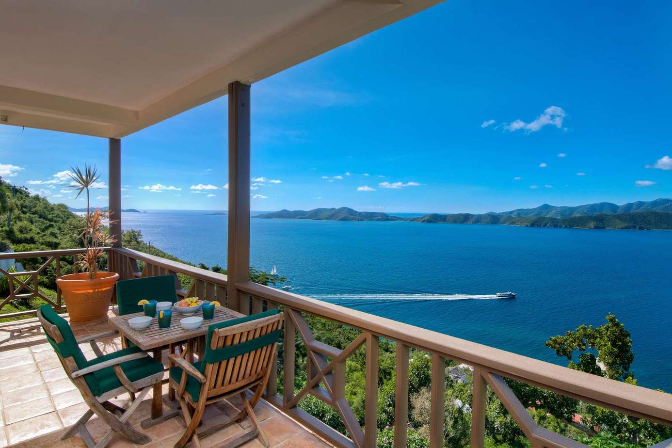 Sunlit balcony with panoramic ocean views and cozy seating
