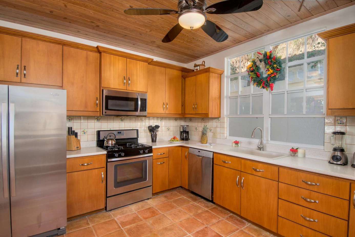 Spacious kitchen with stainless steel appliances and warm wood cabinetry