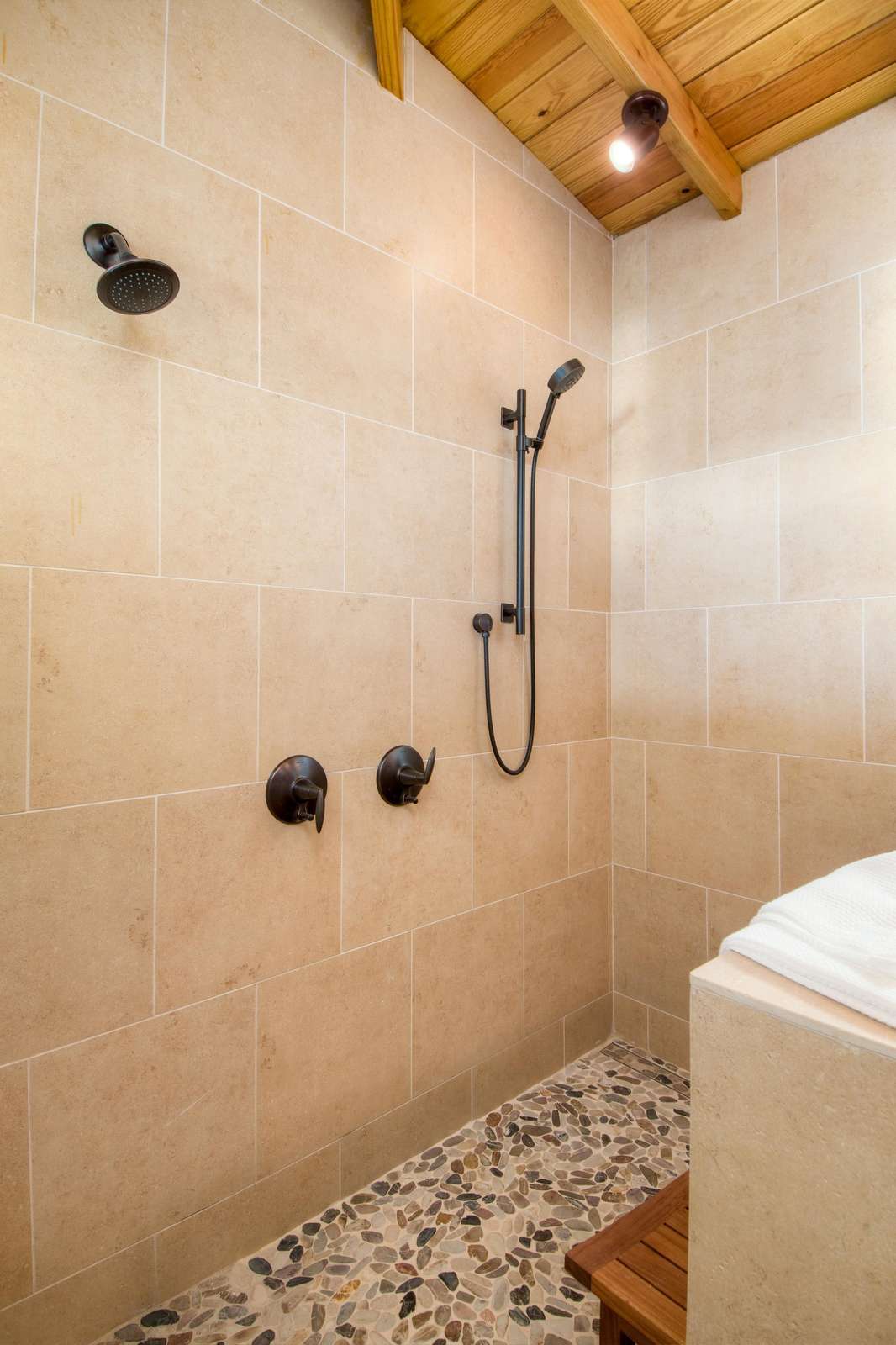 Modern shower with sleek fixtures and pebble tile floor