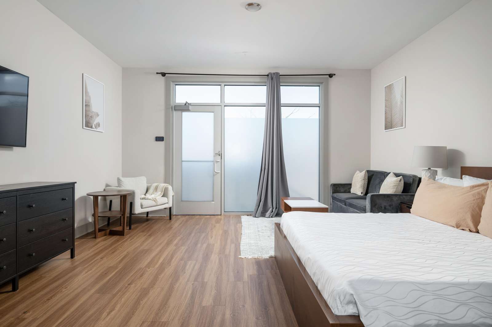 Bright and airy bedroom with cozy seating and balcony access - property