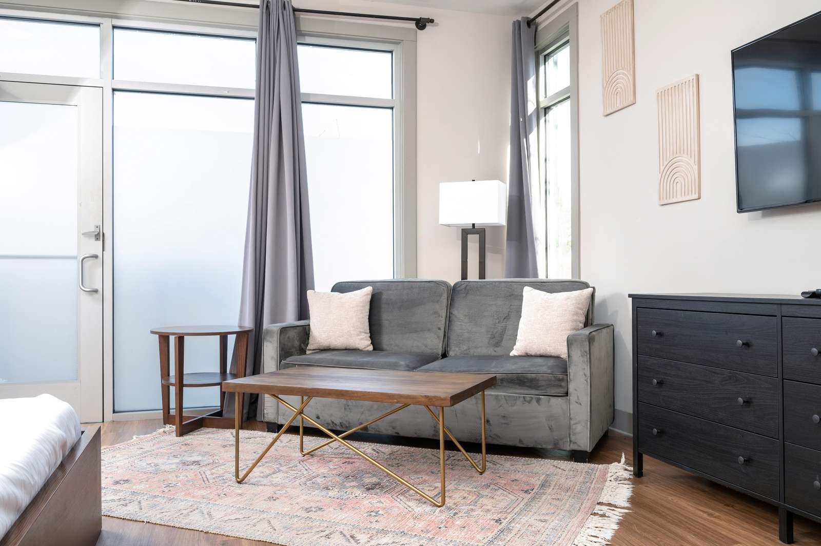 Bright living room with cozy sofa and natural light - property