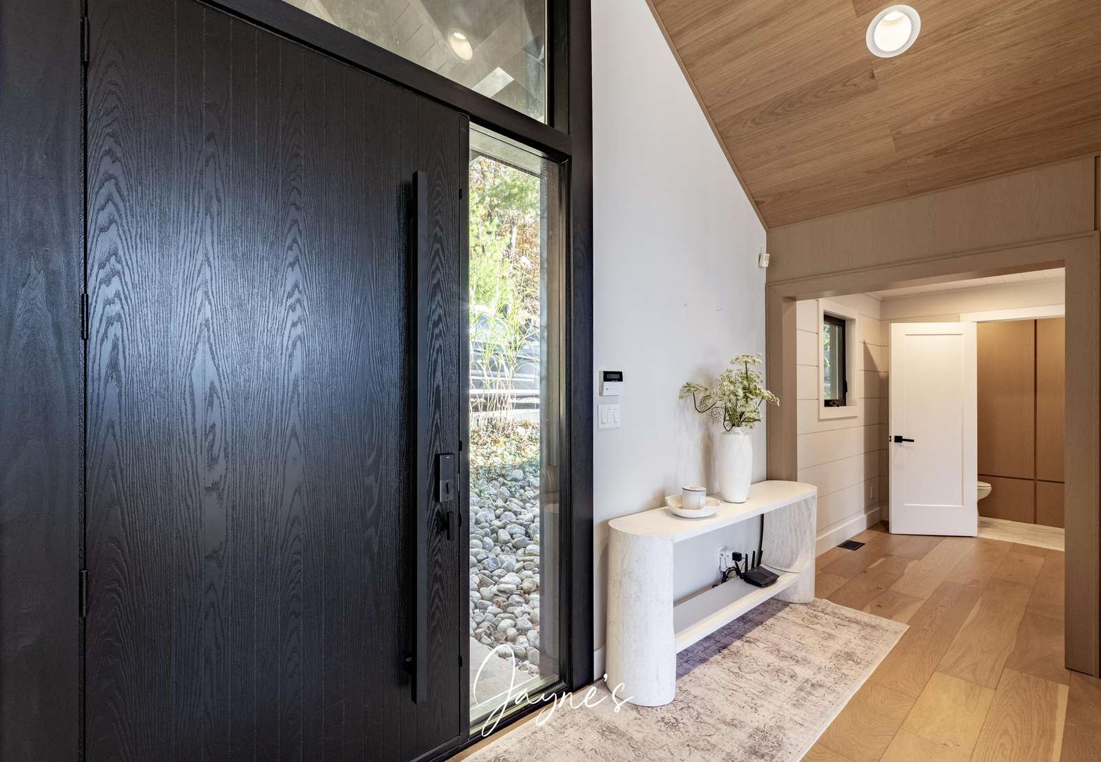 Bright and airy entryway with modern black door and natural light