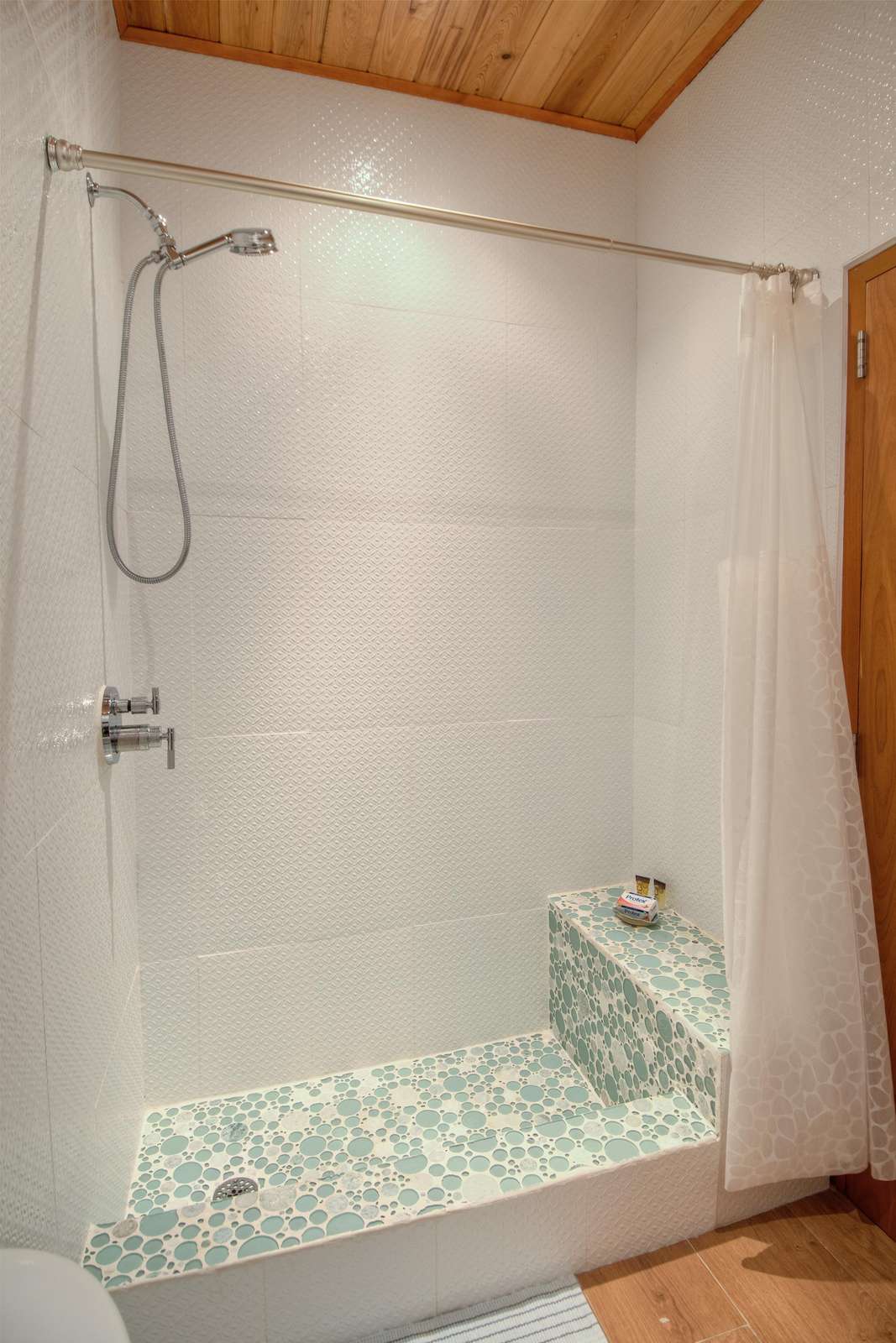 Bright, modern shower with pebble-tile flooring for a spa feel