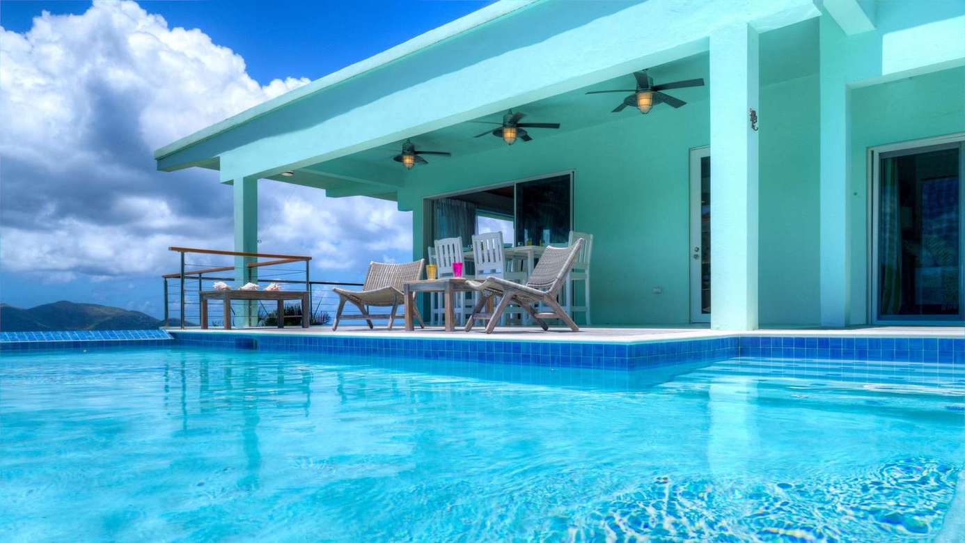 Poolside patio with panoramic ocean views and shaded dining area