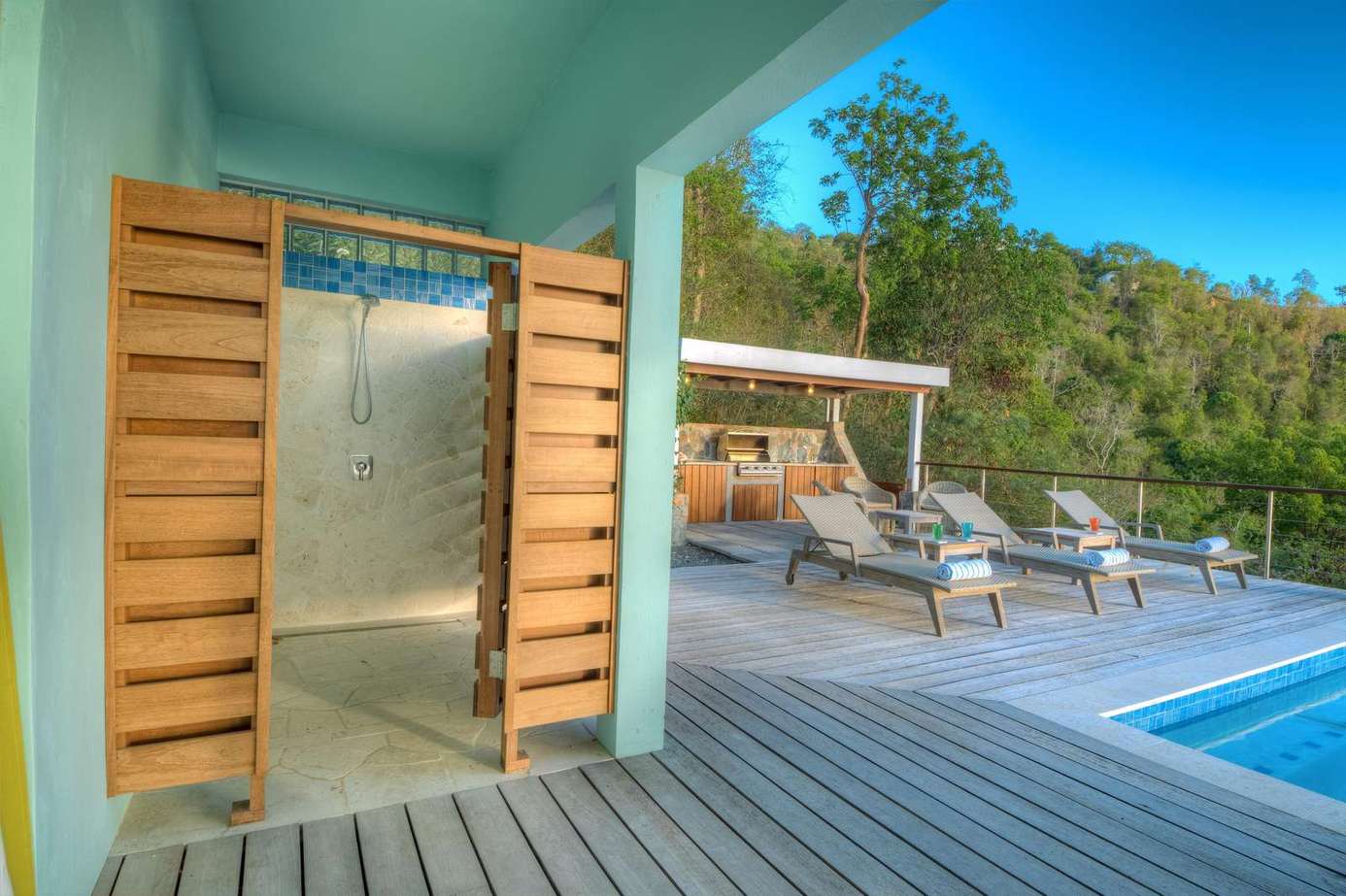 Private outdoor shower and sun-soaked poolside lounge area