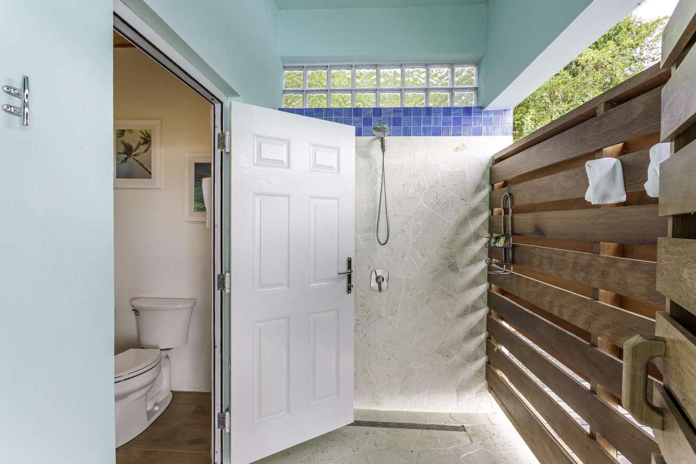 Bright outdoor shower area with private wooden fence