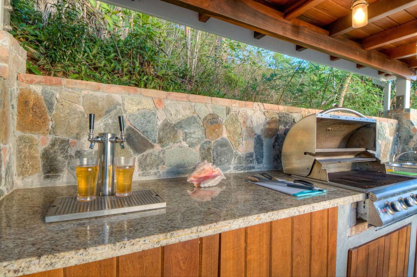 Outdoor kitchen with stone backsplash and built-in grill