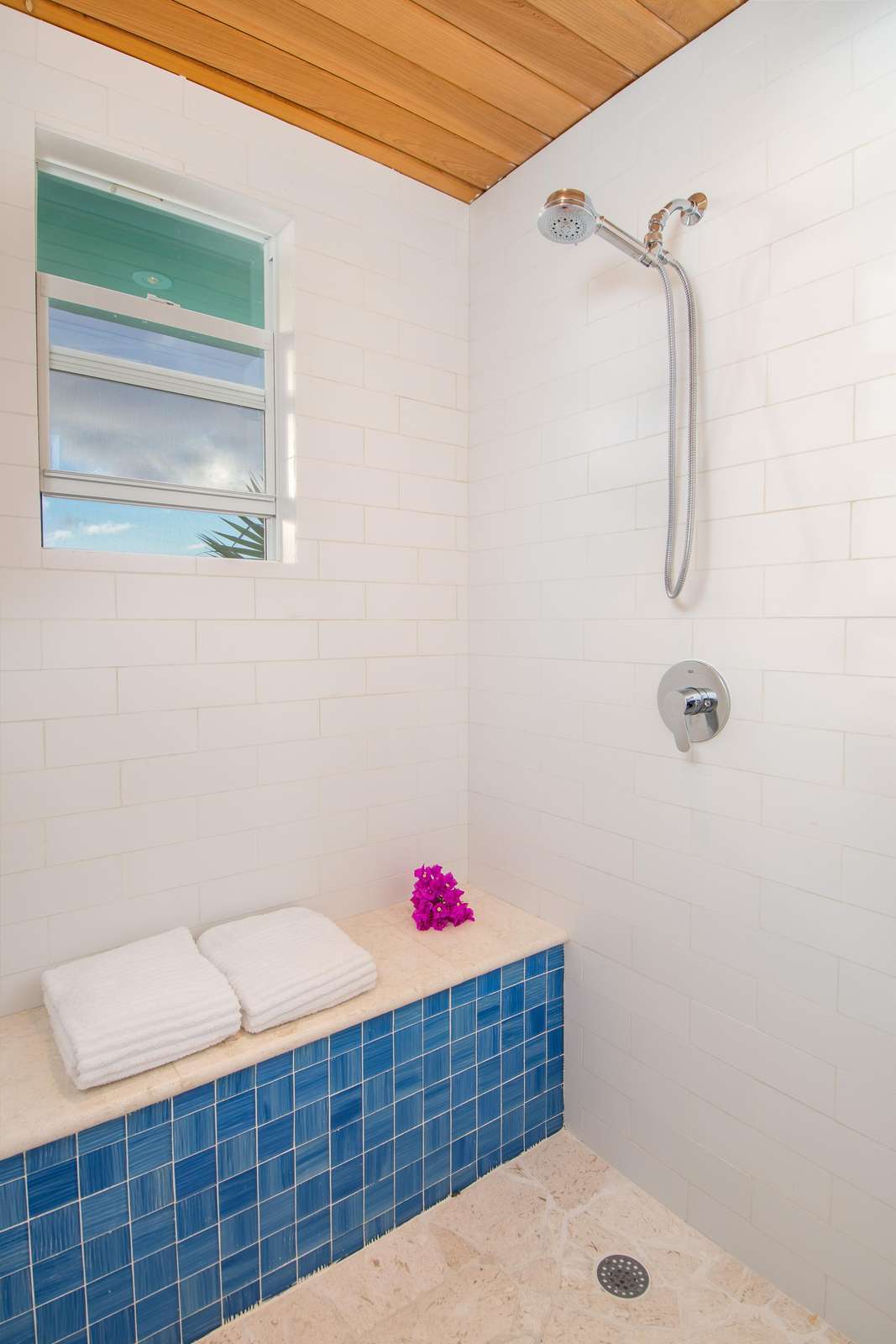 Bright, modern shower with cozy bench seating area