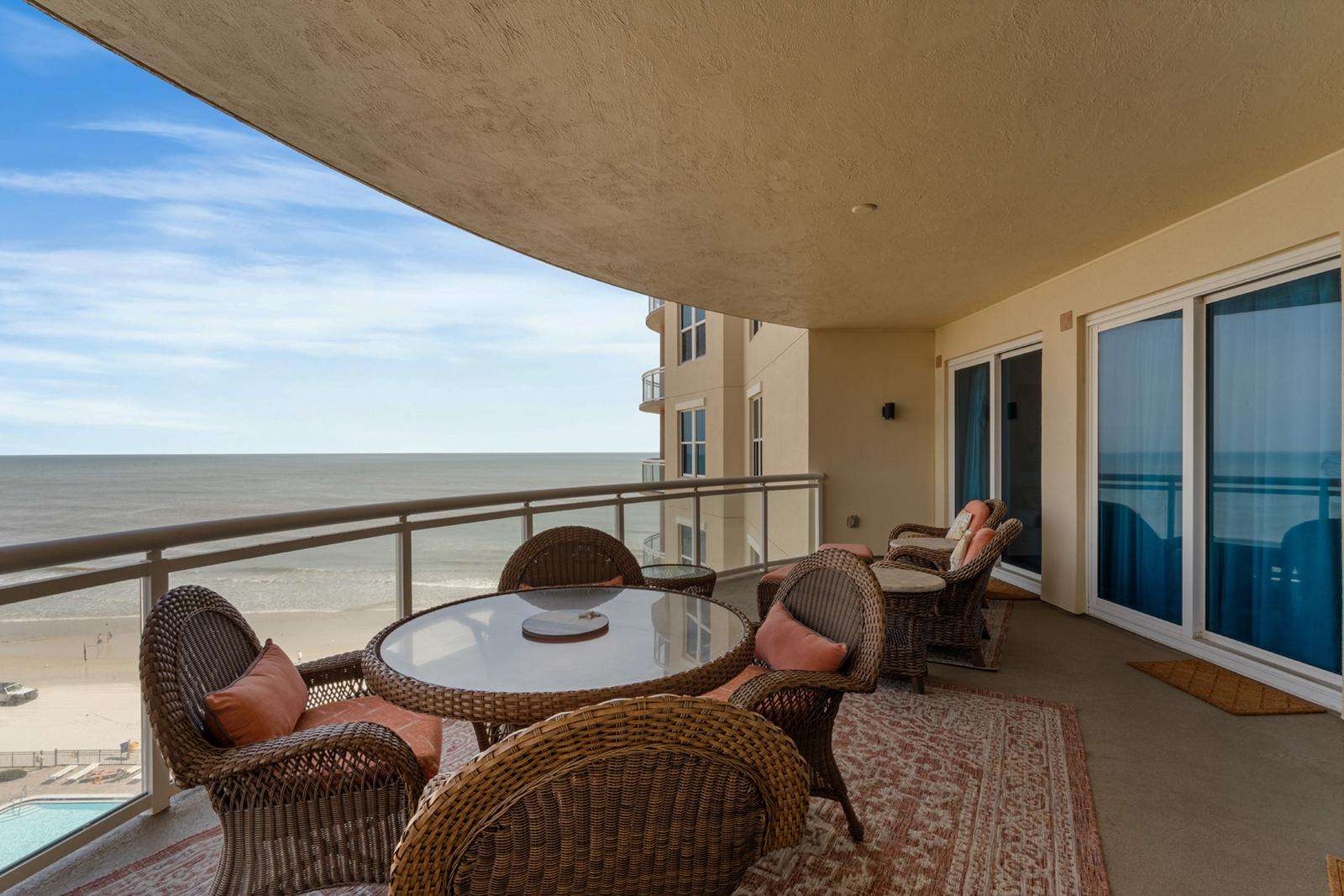 Spacious oceanfront balcony with cozy seating and stunning views - property