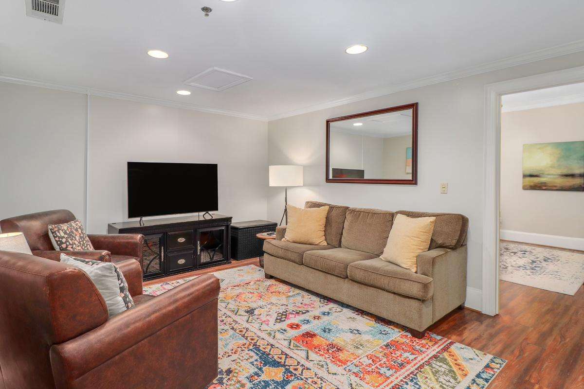 Cozy living room with plush seating and vibrant rug - property