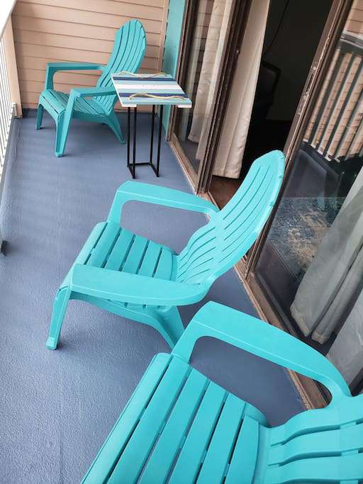 it's a comfortable pretty balcony that has a cool view of the palms, beach, and water