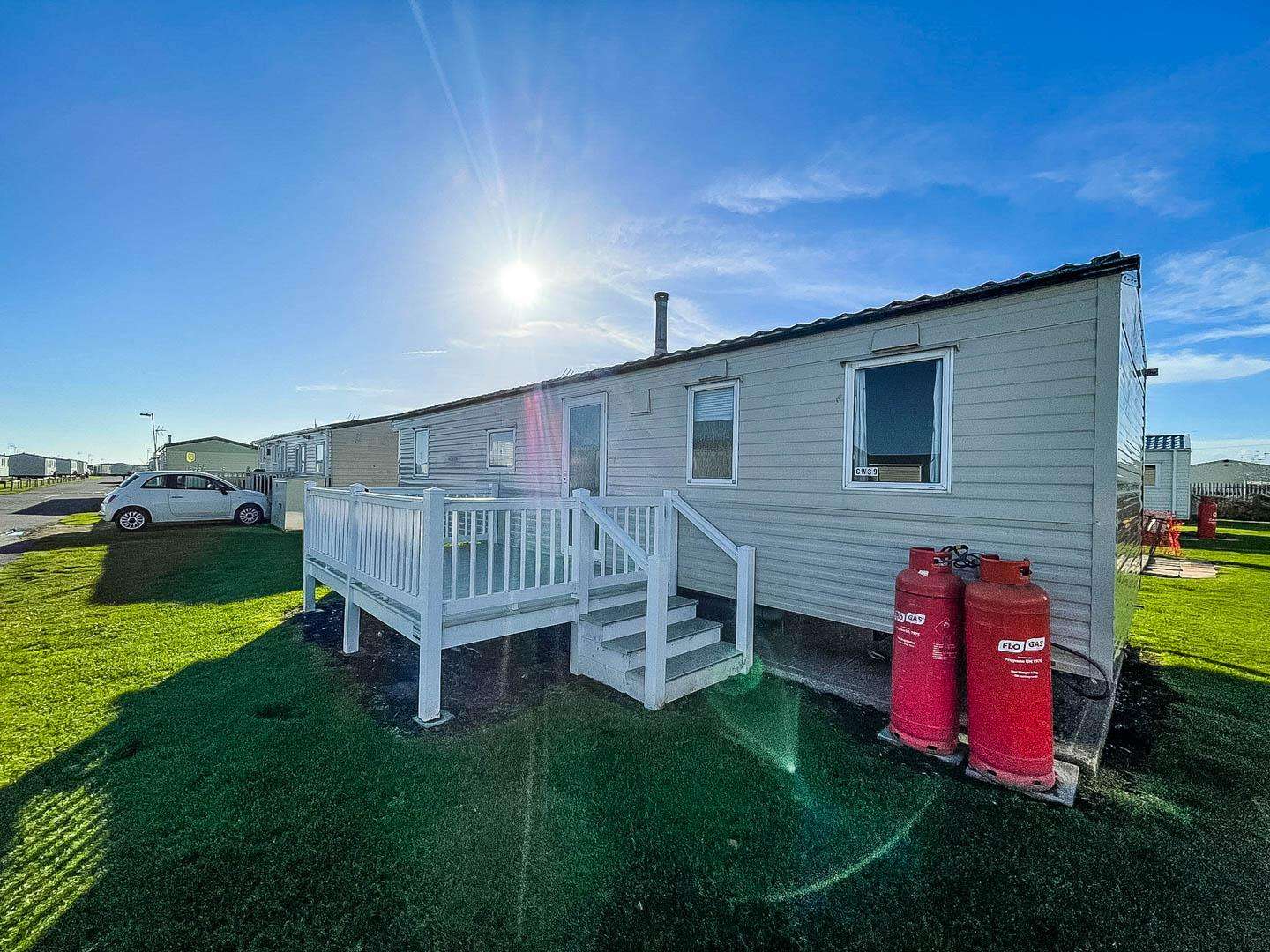Relax on the decking of your private holiday home at St Osyth Beach & Martello Beach Holiday Park, a top choice for UK holidays in Essex. - property
