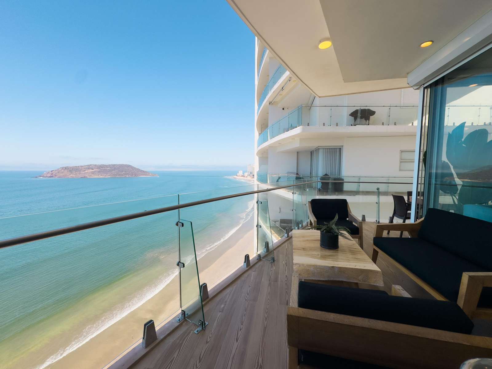 Oceanfront balcony with panoramic sea views and cozy seating - property