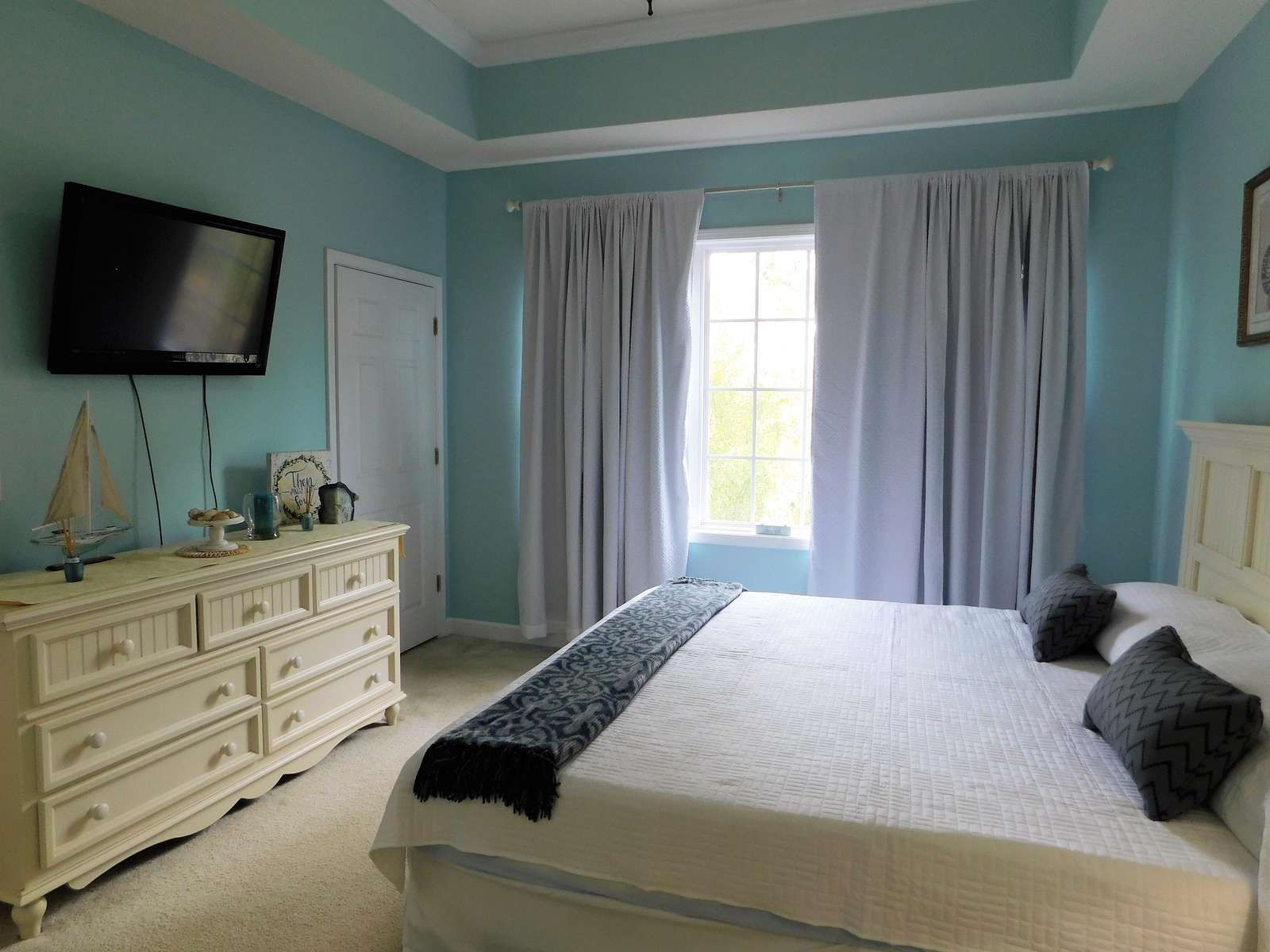 Master bedroom with flatscreen tv and large windows