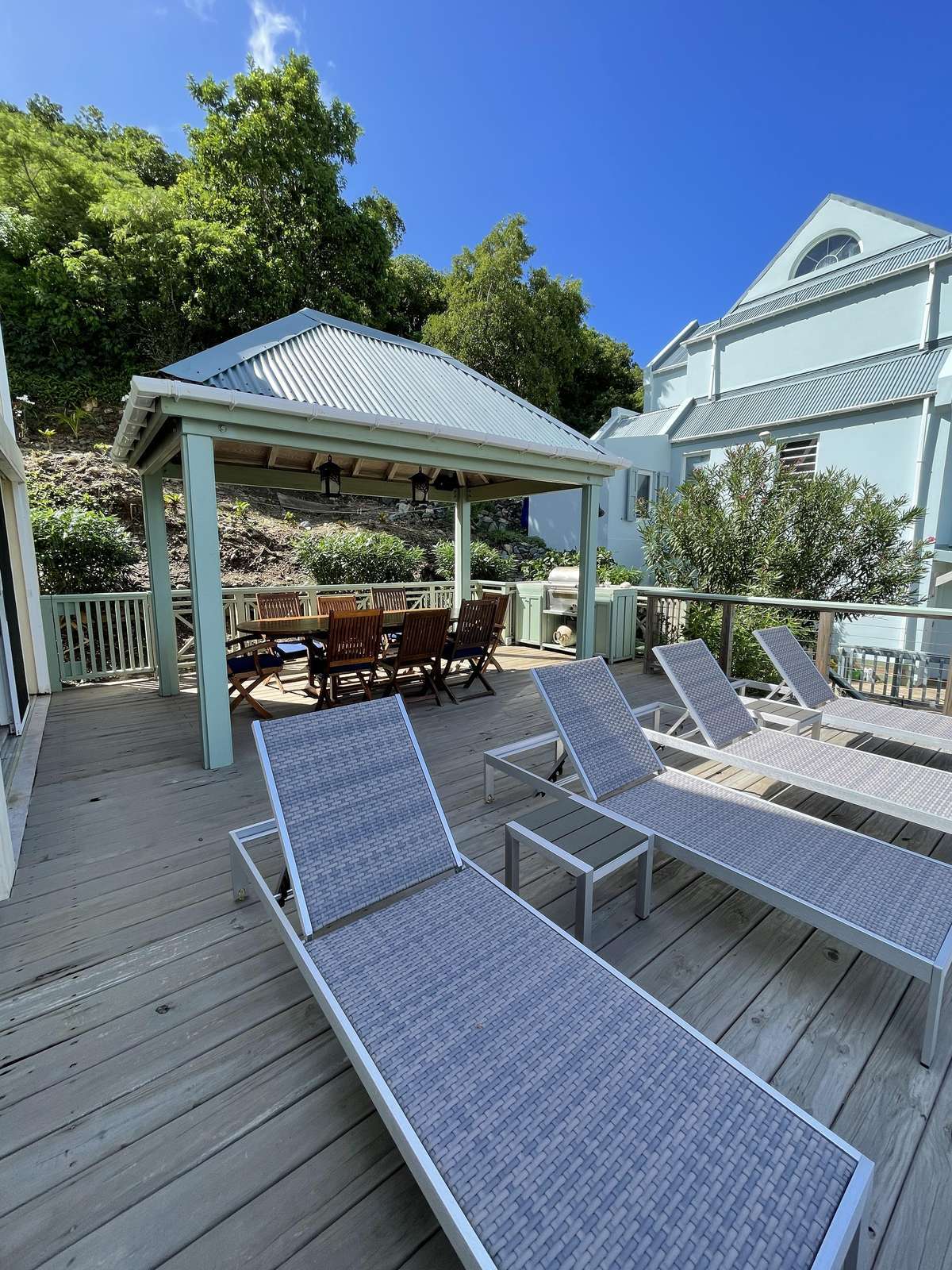 Sun-soaked patio with loungers and shaded dining area