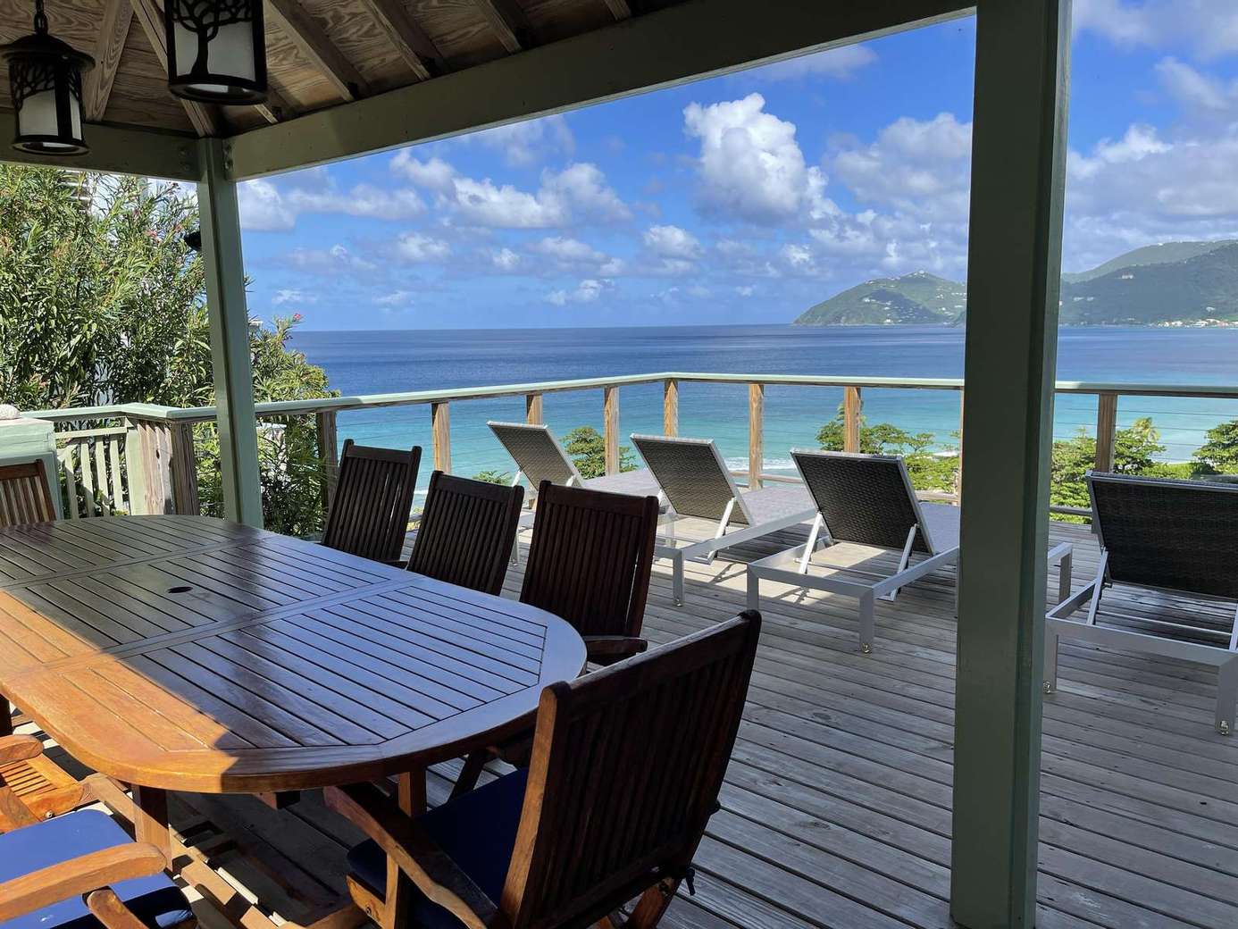 Spacious deck dining with stunning ocean views and lounge chairs