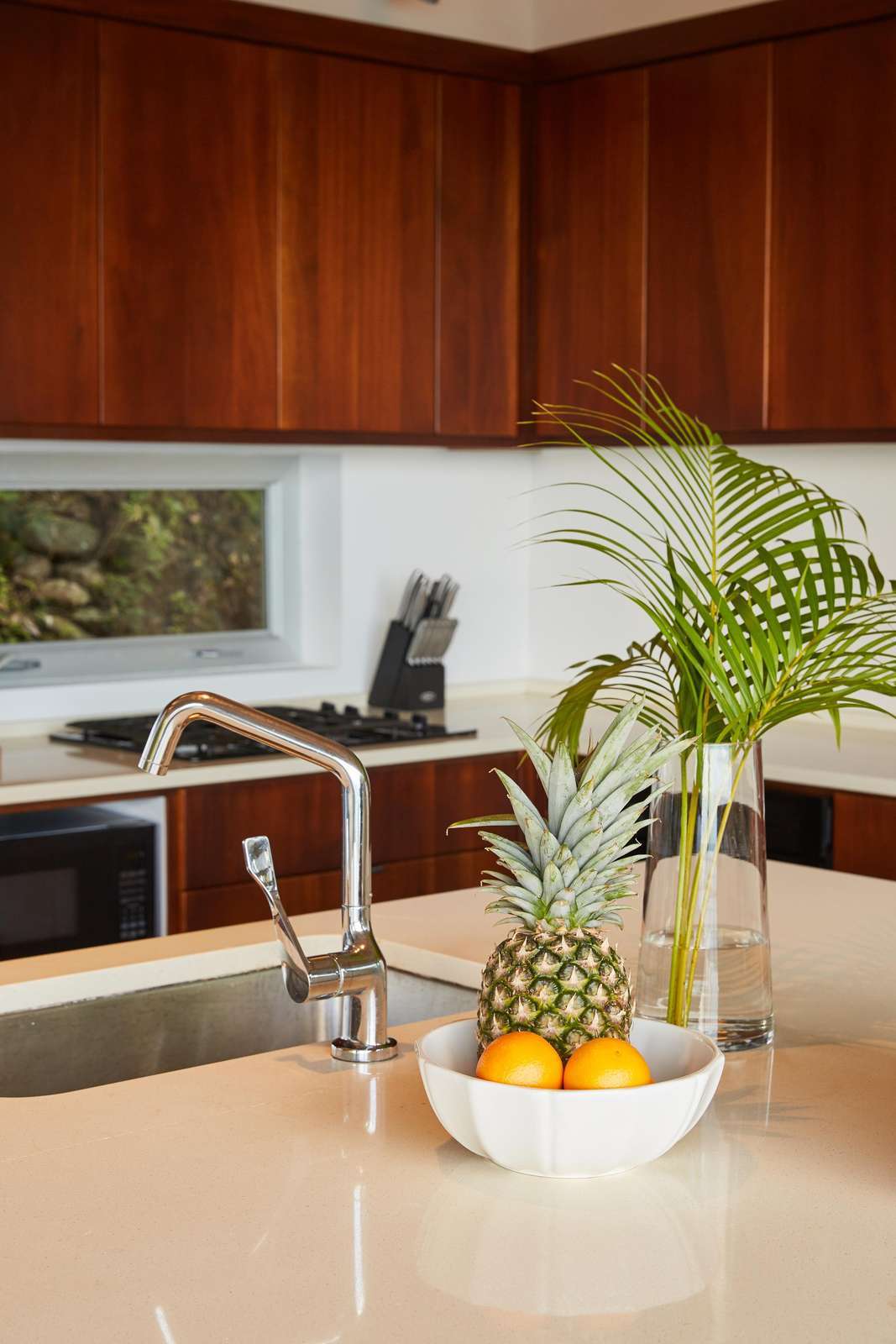 Modern kitchen with sleek wood cabinets and fresh fruit centerpiece