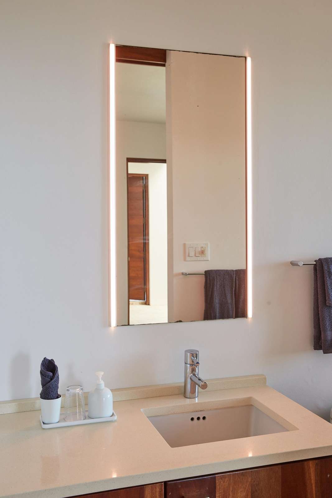 Modern bathroom sink area with sleek mirror and clean design