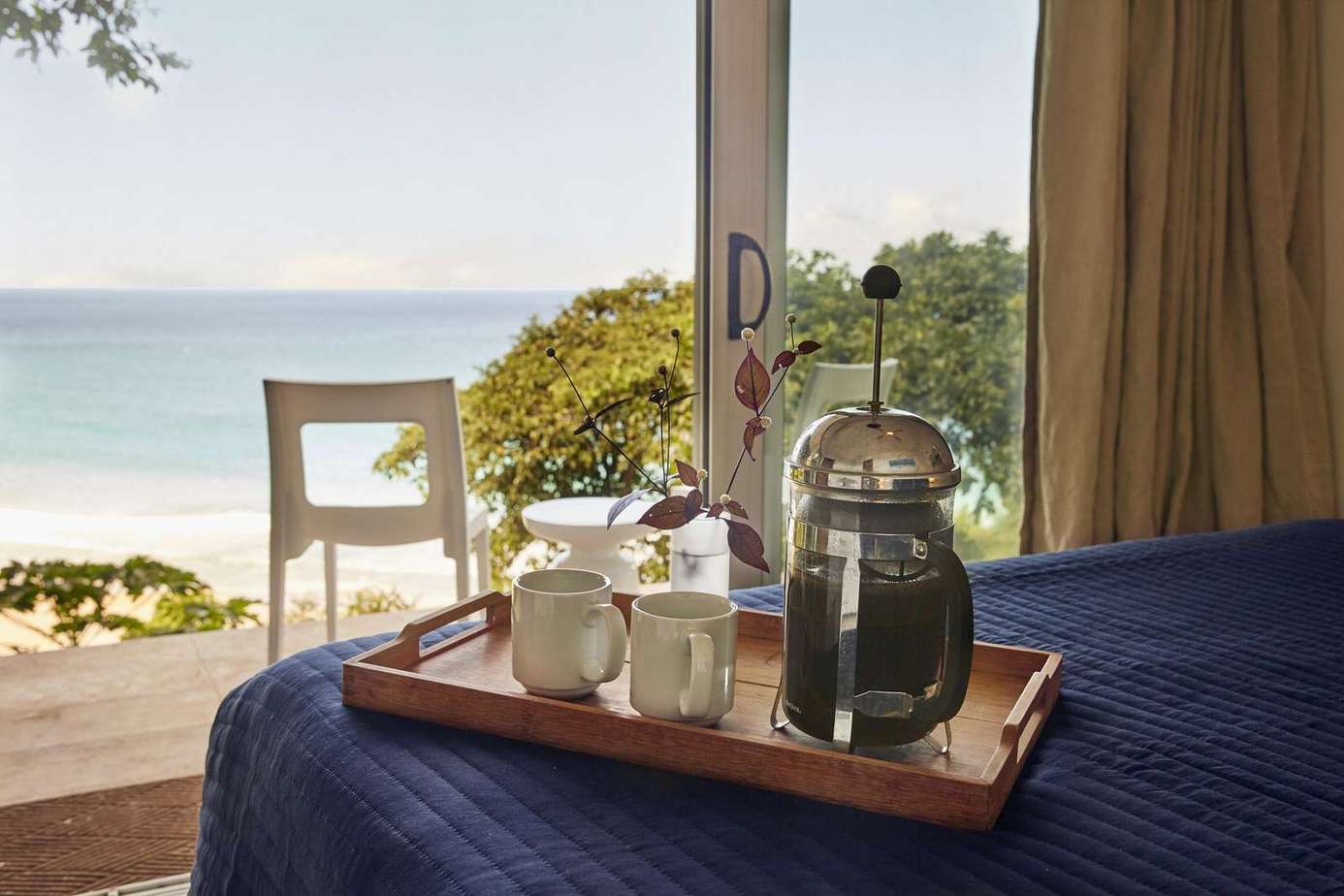 Cozy bedroom retreat with serene ocean views and morning coffee.