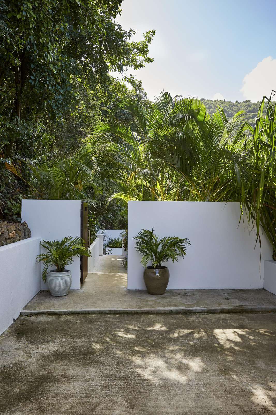 Secluded outdoor patio with lush tropical greenery and cozy seating