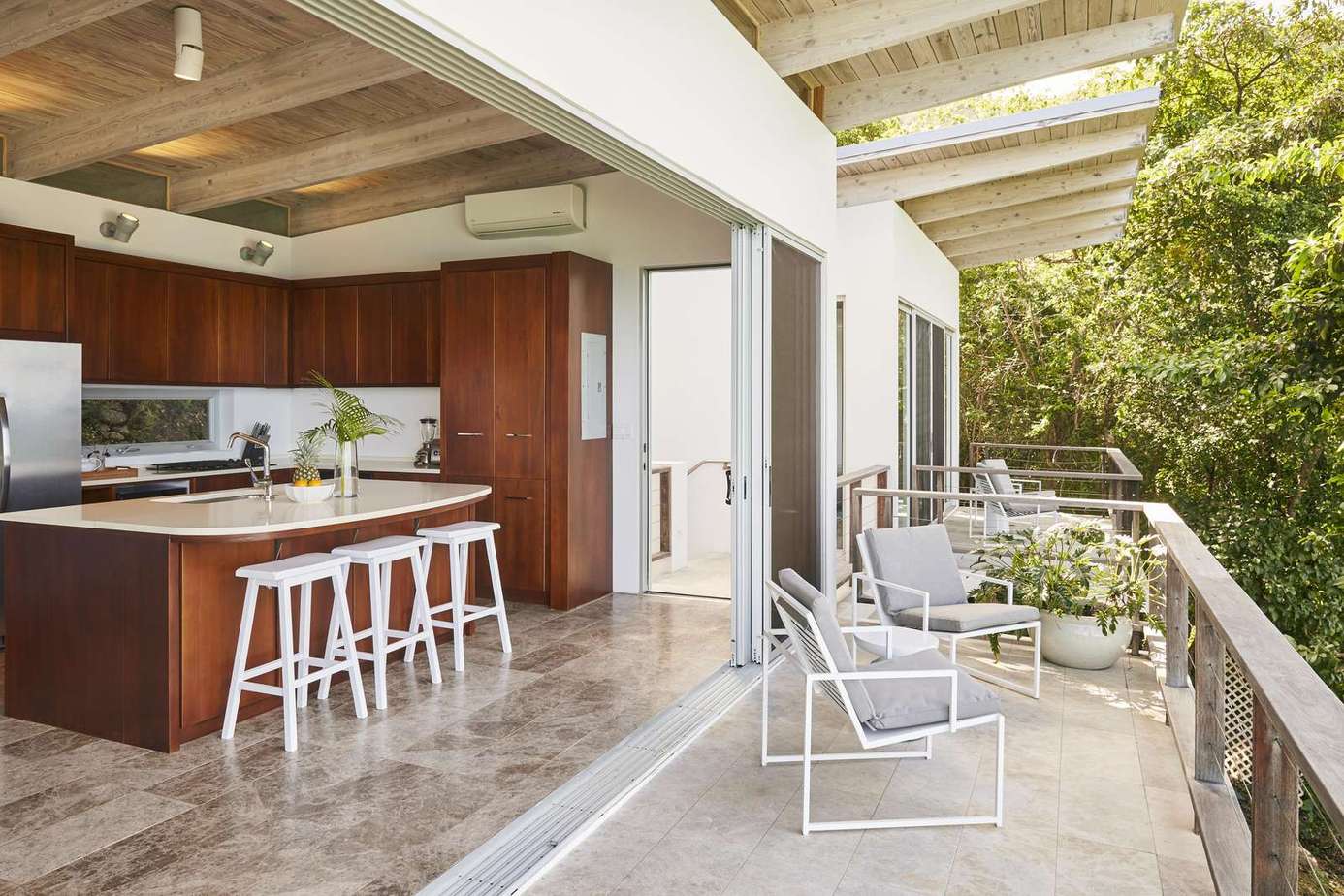 Open-concept kitchen and balcony with lush garden views