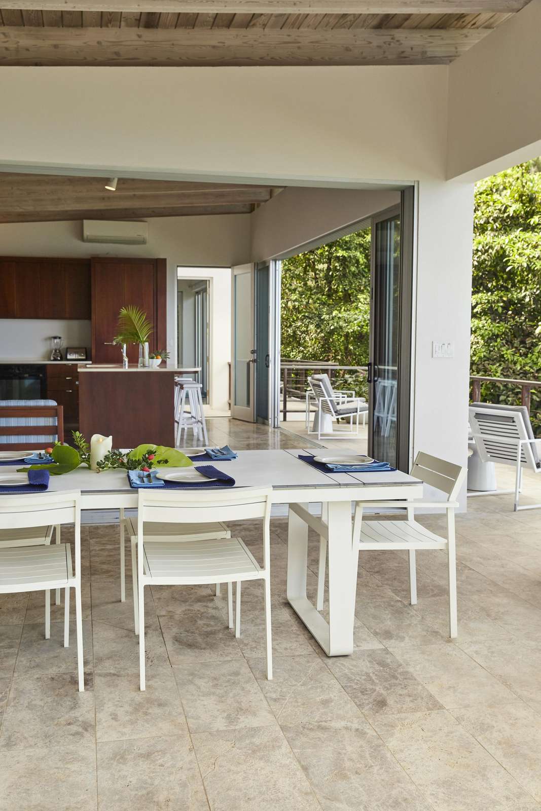 Open-air dining area with modern kitchen and garden views