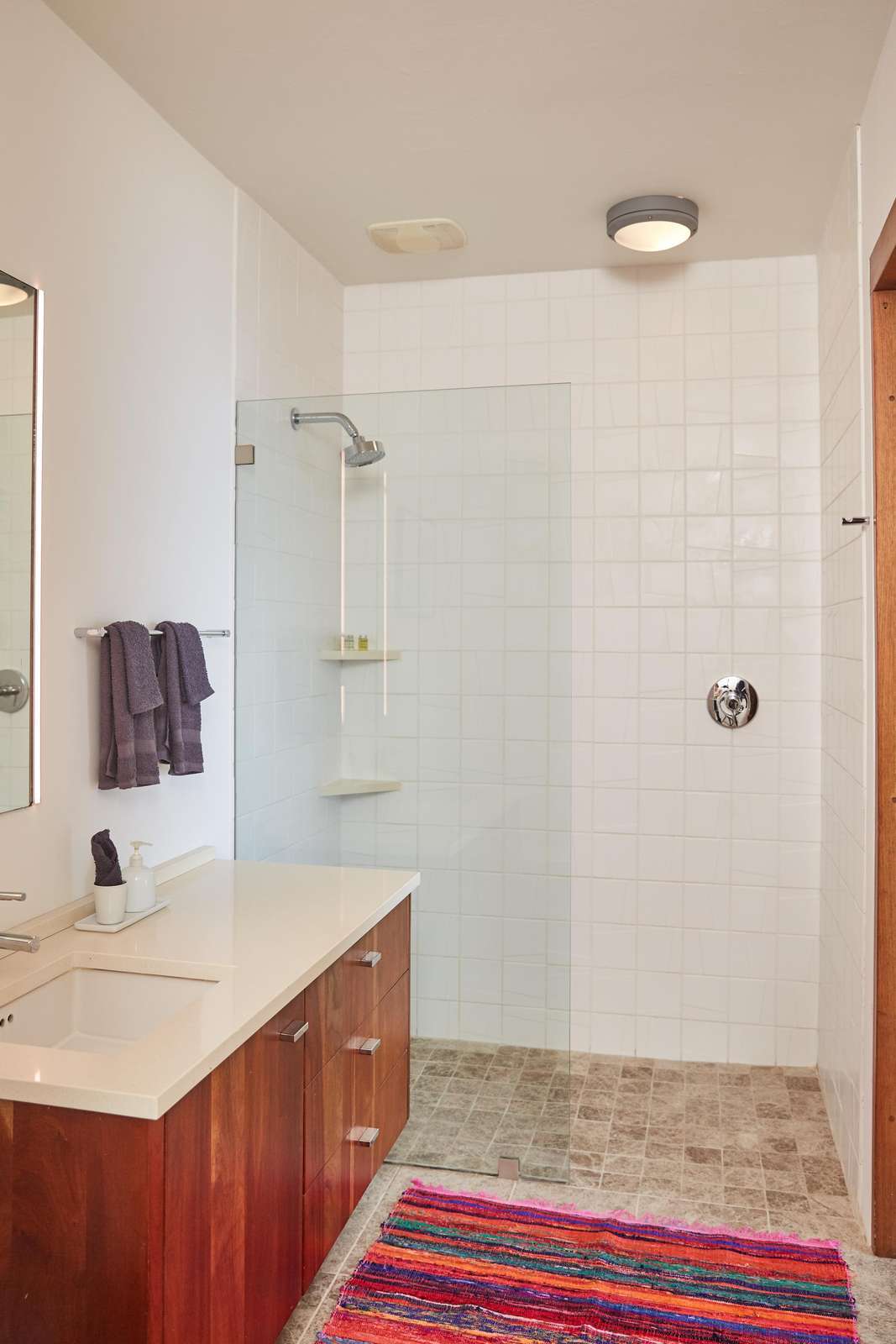 Bright, modern bathroom with spacious walk-in shower and warm wood accents