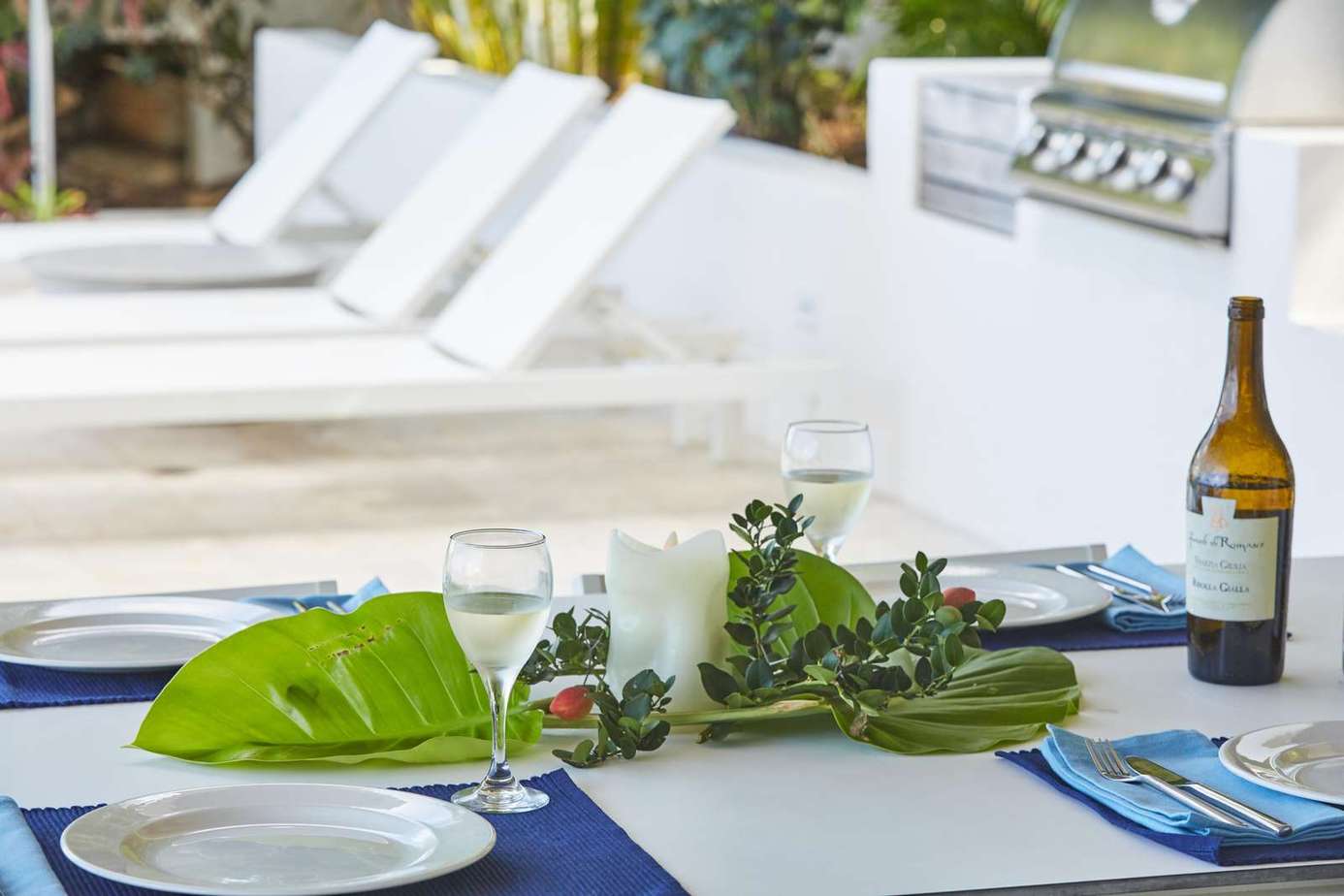 Outdoor dining area with poolside lounge and grill
