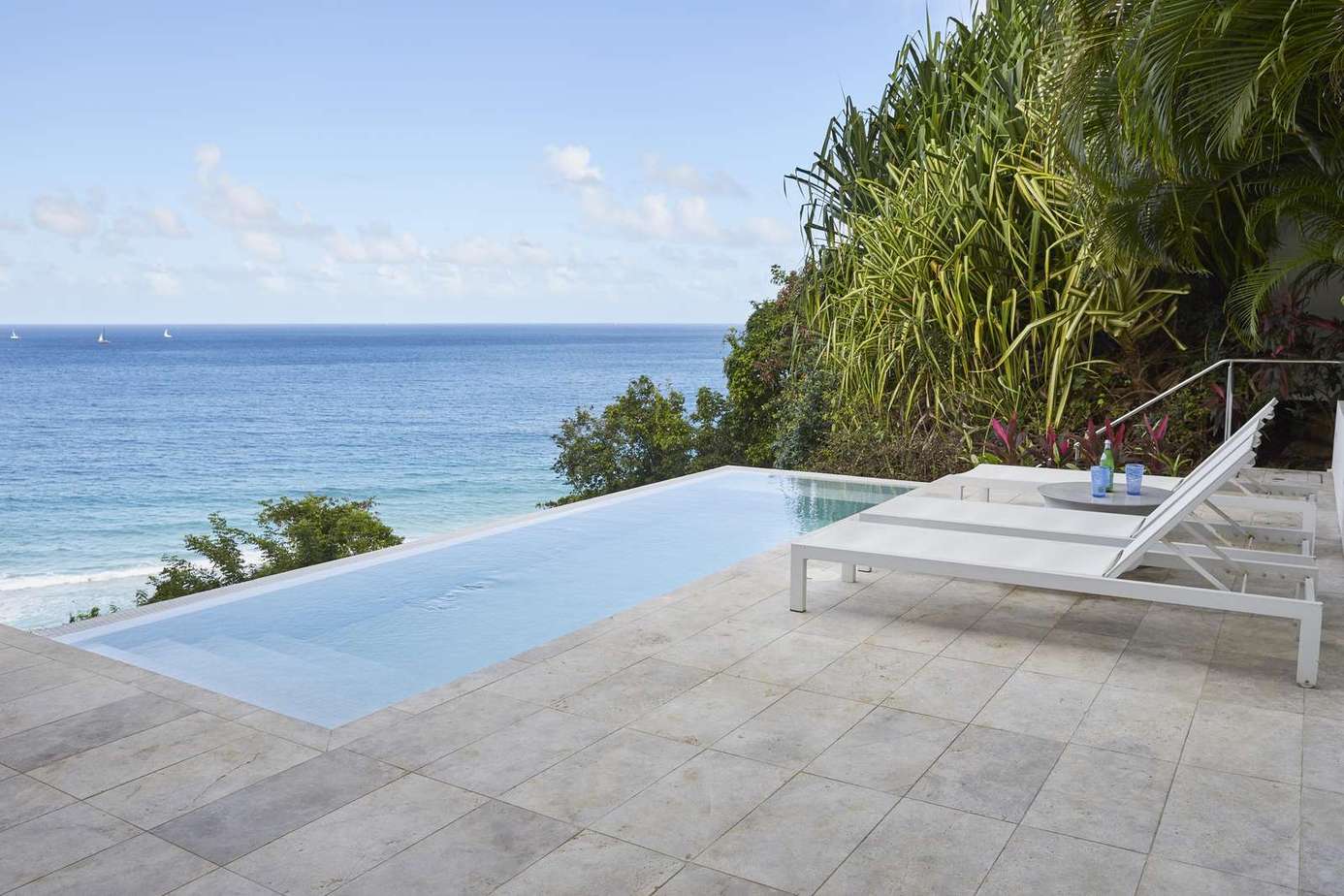 Infinity pool with ocean views and sun loungers
