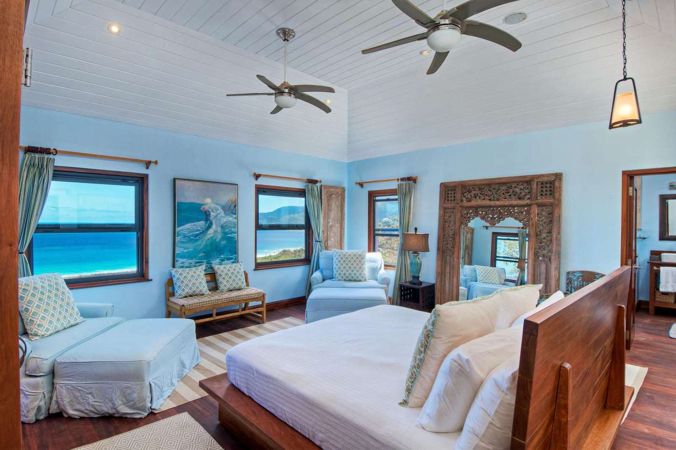 Spacious bedroom with ocean views and cozy seating area