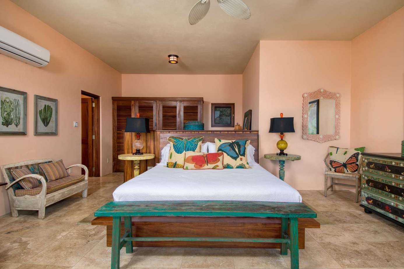 Spacious bedroom with vibrant decor and cozy seating area