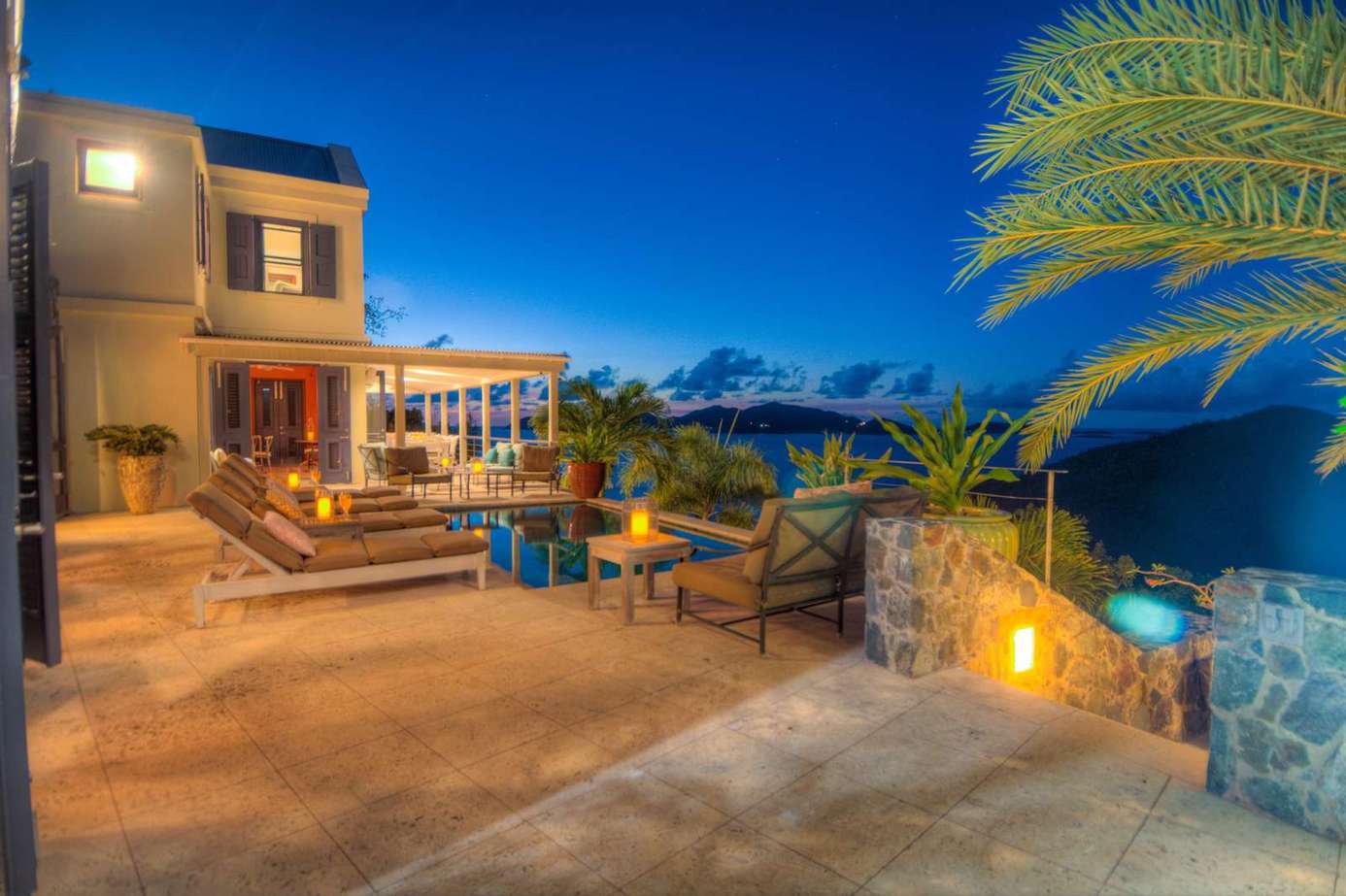 Spacious outdoor patio with pool and mountain views at dusk
