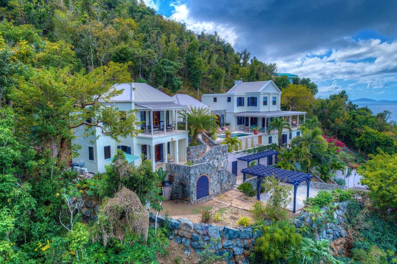 Secluded hillside villa with panoramic ocean views and lush greenery