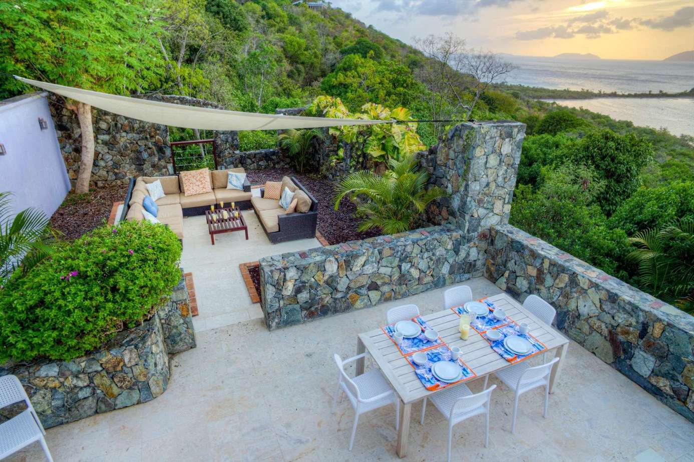 Secluded stone patio with cozy dining and lounge areas