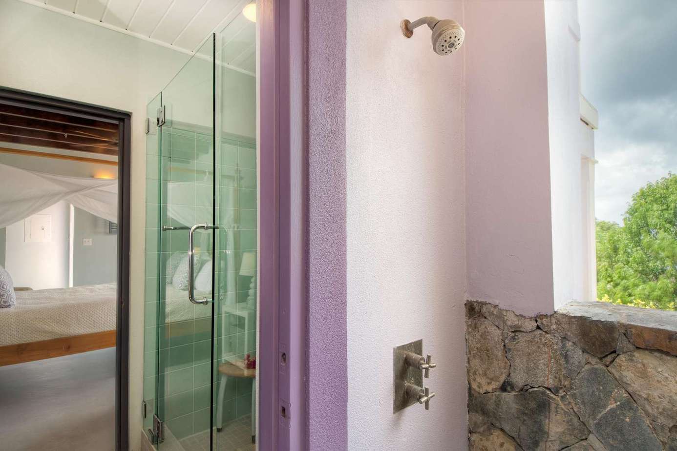Bright, airy bathroom with refreshing outdoor shower and natural stone accents
