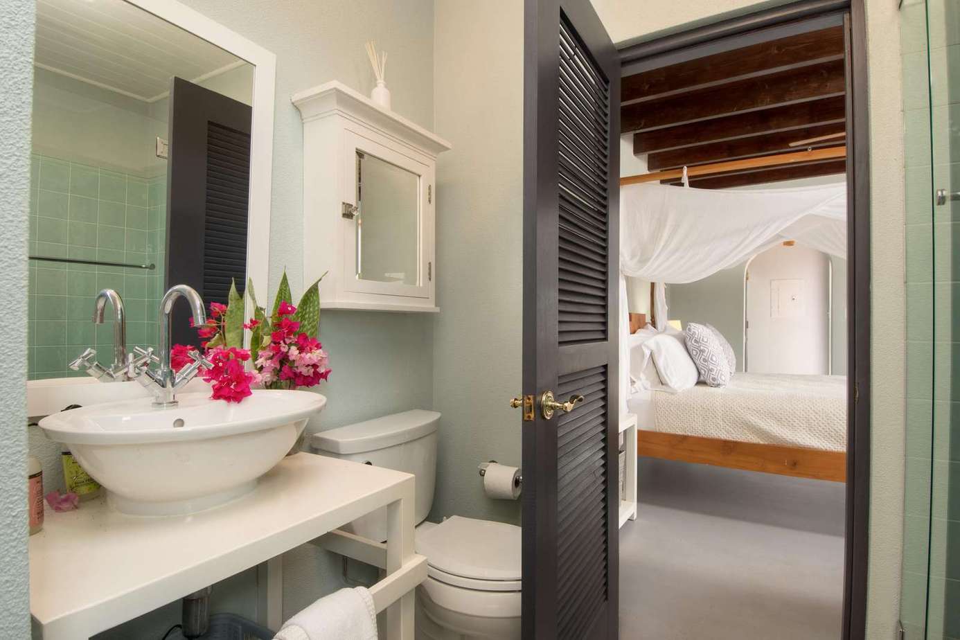 Charming bathroom with fresh floral accents and cozy bedroom access