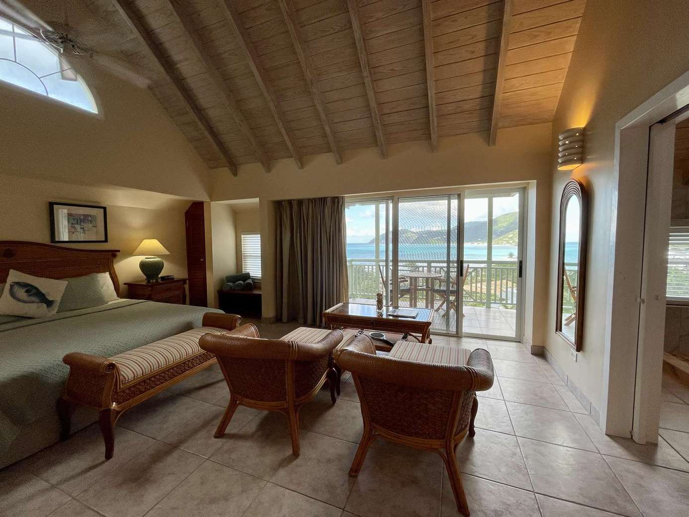 Spacious bedroom with vaulted ceilings and scenic balcony views